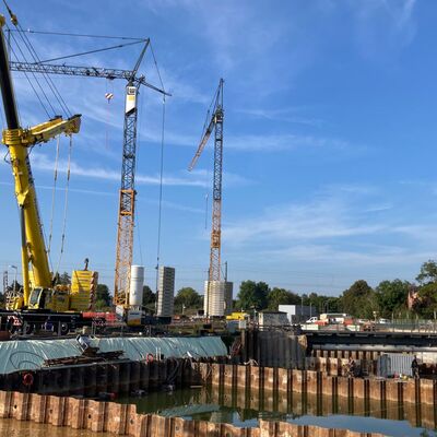 Große Schwerlastkräne auf einer Baustelle mit blauem Himmel