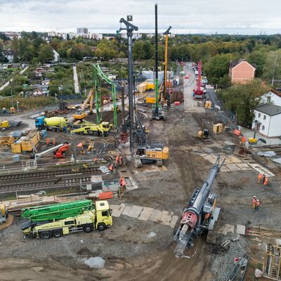 Überblick einer Baustelle an den Gleisen mit LKWs und Kränen