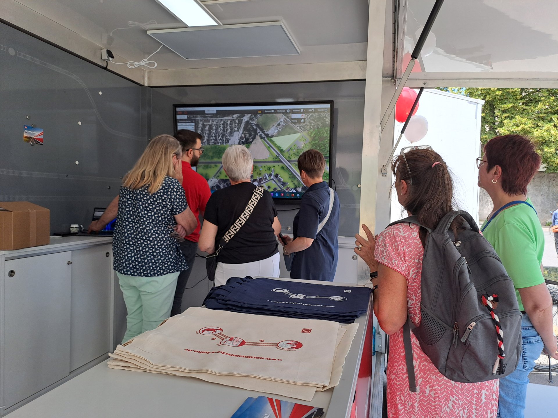 Besucher und Besucherinnen im DB Infomobil beim Infopunkt Virtueller Flug